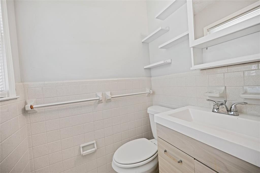 7039 Rockbridge Road Southwest Stone Mountain, GA 30087 - Photo 21 of 28 a bathroom with a sink a toilet and shower