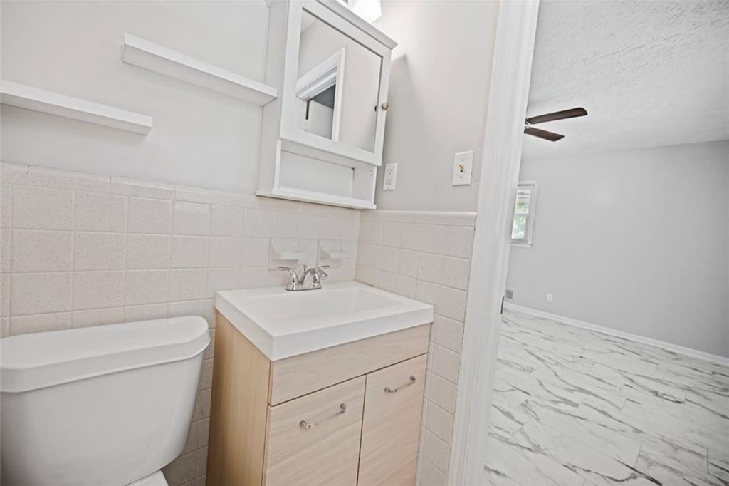 7039 Rockbridge Road Southwest Stone Mountain, GA 30087 - Photo 22 of 28 a bathroom with a sink a toilet and vanity