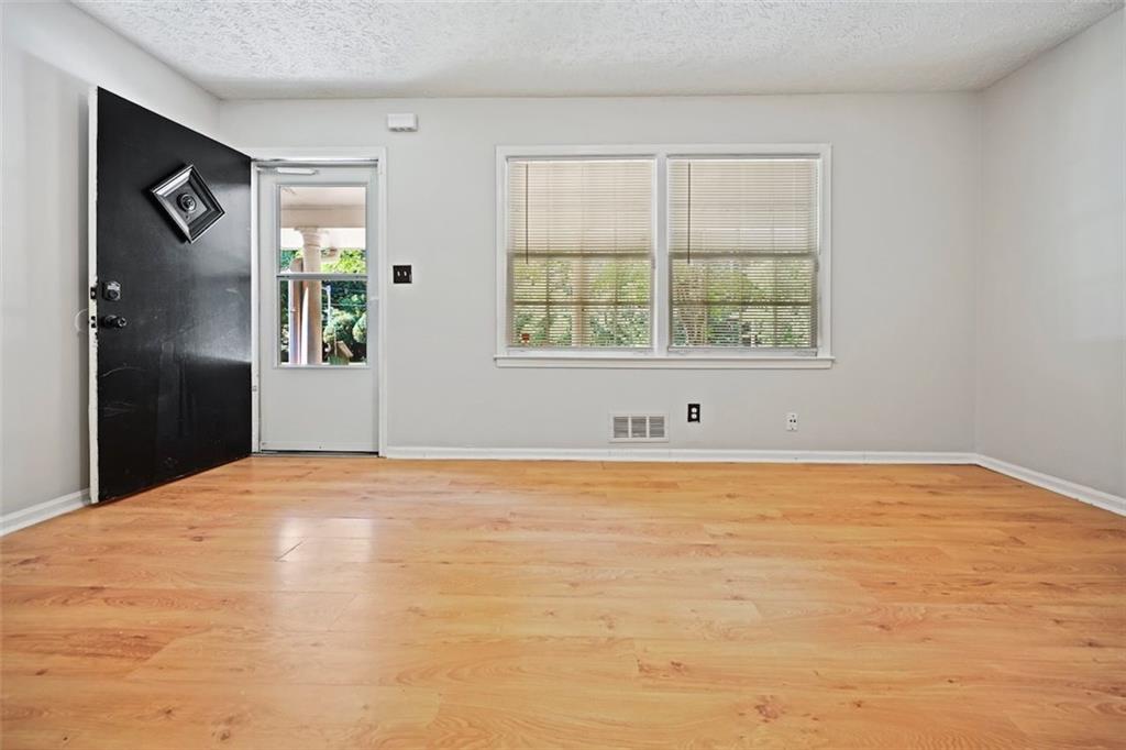 7039 Rockbridge Road Southwest Stone Mountain, GA 30087 - Photo 23 of 28 a view of an empty room with a window