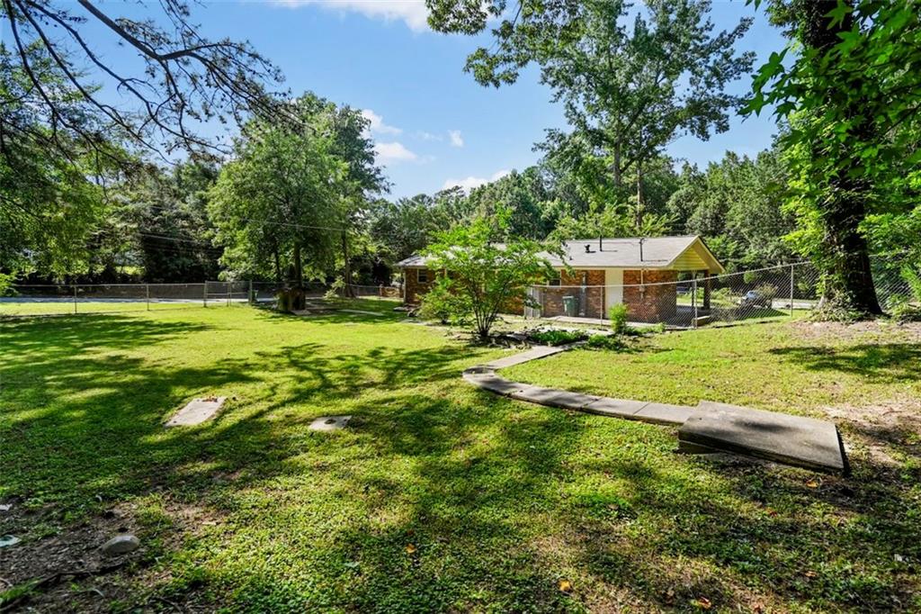 7039 Rockbridge Road Southwest Stone Mountain, GA 30087 - Photo 28 of 28 a view of a house with a big yard