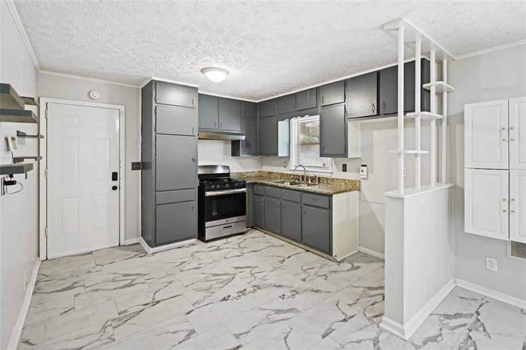 7039 Rockbridge Road Southwest Stone Mountain, GA 30087 - Photo 7 of 28 a kitchen with stainless steel appliances granite countertop a stove a refrigerator and a sink