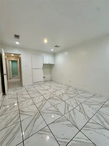 an empty room with ceiling fan and window