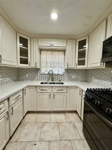 a kitchen with stainless steel appliances granite countertop a stove sink and cabinets