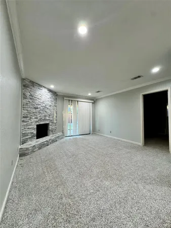 a view of an empty room with a fireplace and a window