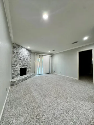 a view of an empty room with a fireplace and a window