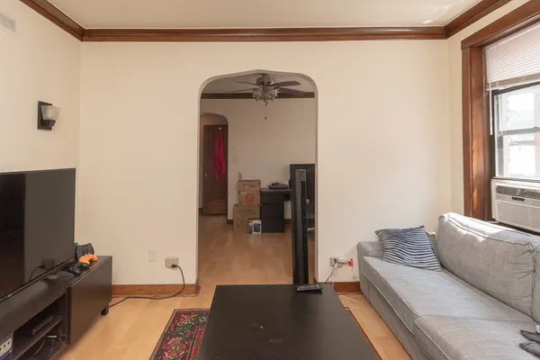 a living room with a bed furniture and a flat screen tv