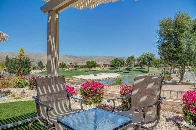 a view of a chairs and table in patio next to a yard