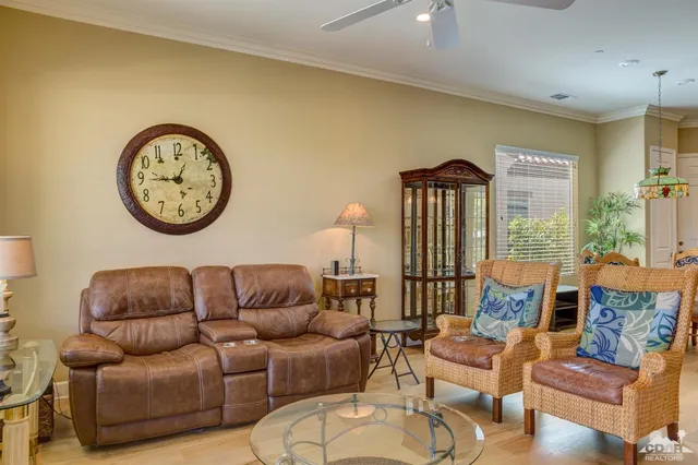 a living room with furniture a clock on wall and a large window