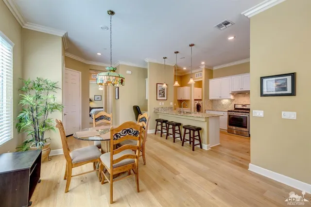 a view of a dining room and livingroom with furniture wooden floor a chandelier