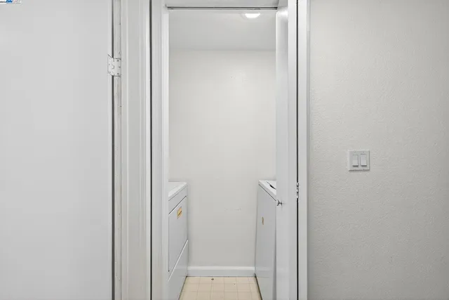 a bedroom with a bed and a walk in closet with wooden floor