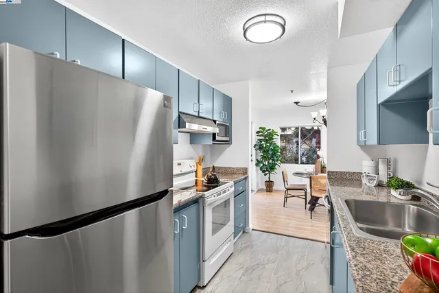 a kitchen with stainless steel appliances granite countertop a sink stove and cabinets
