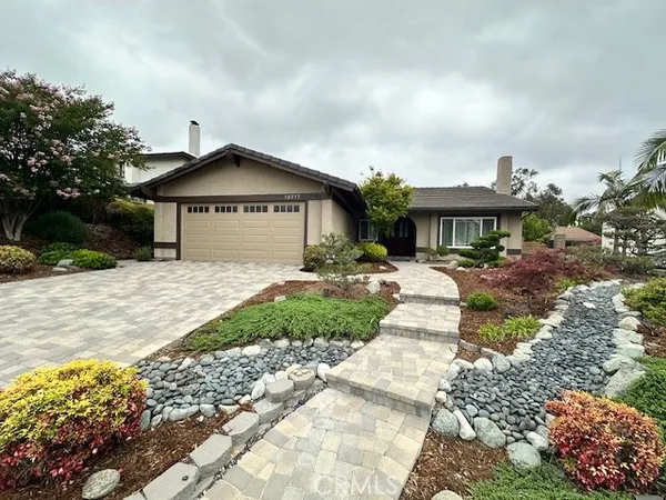 a front view of a house with a yard and trees