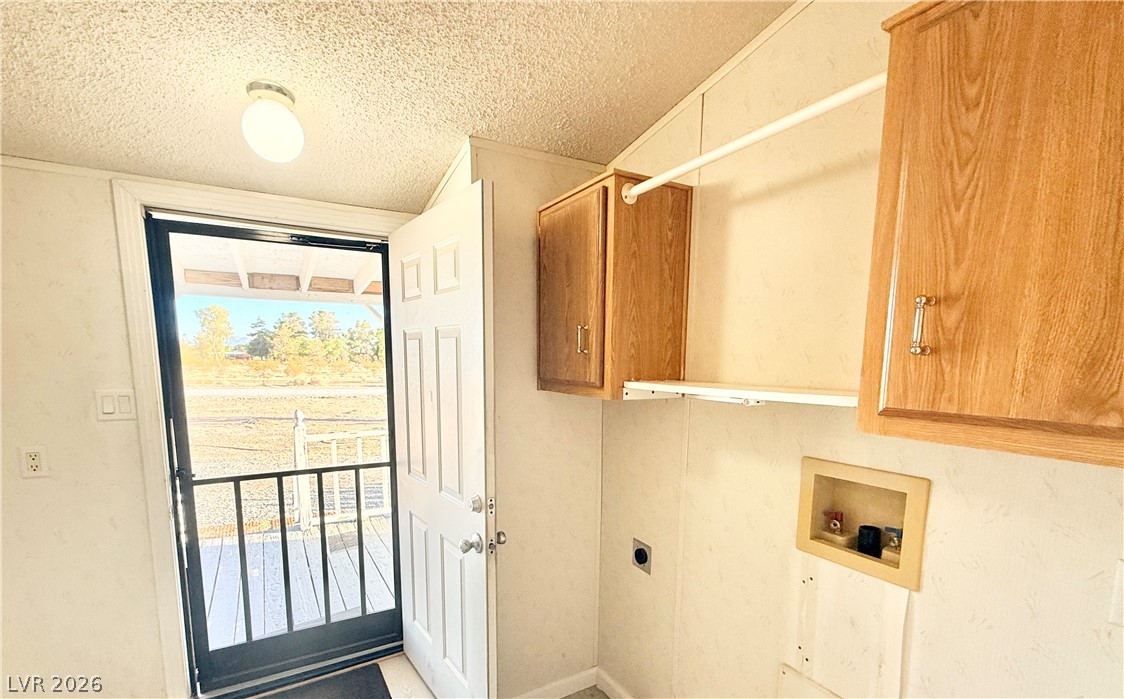 6471 Hafen Ranch Road Pahrump, NV 89061 - Photo 19 of 22 A well-lit laundry area with functional cabinetry and direct outdoor access.