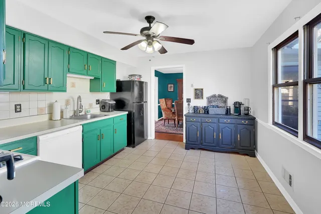 a kitchen with a refrigerator sink and cabinets