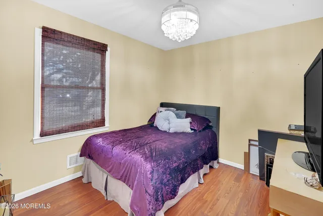 a kitchen with granite countertop white cabinets and wooden floor