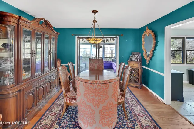 a living room with furniture large windows and wooden floor