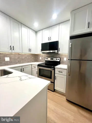 a kitchen with kitchen island a sink stainless steel appliances and cabinets