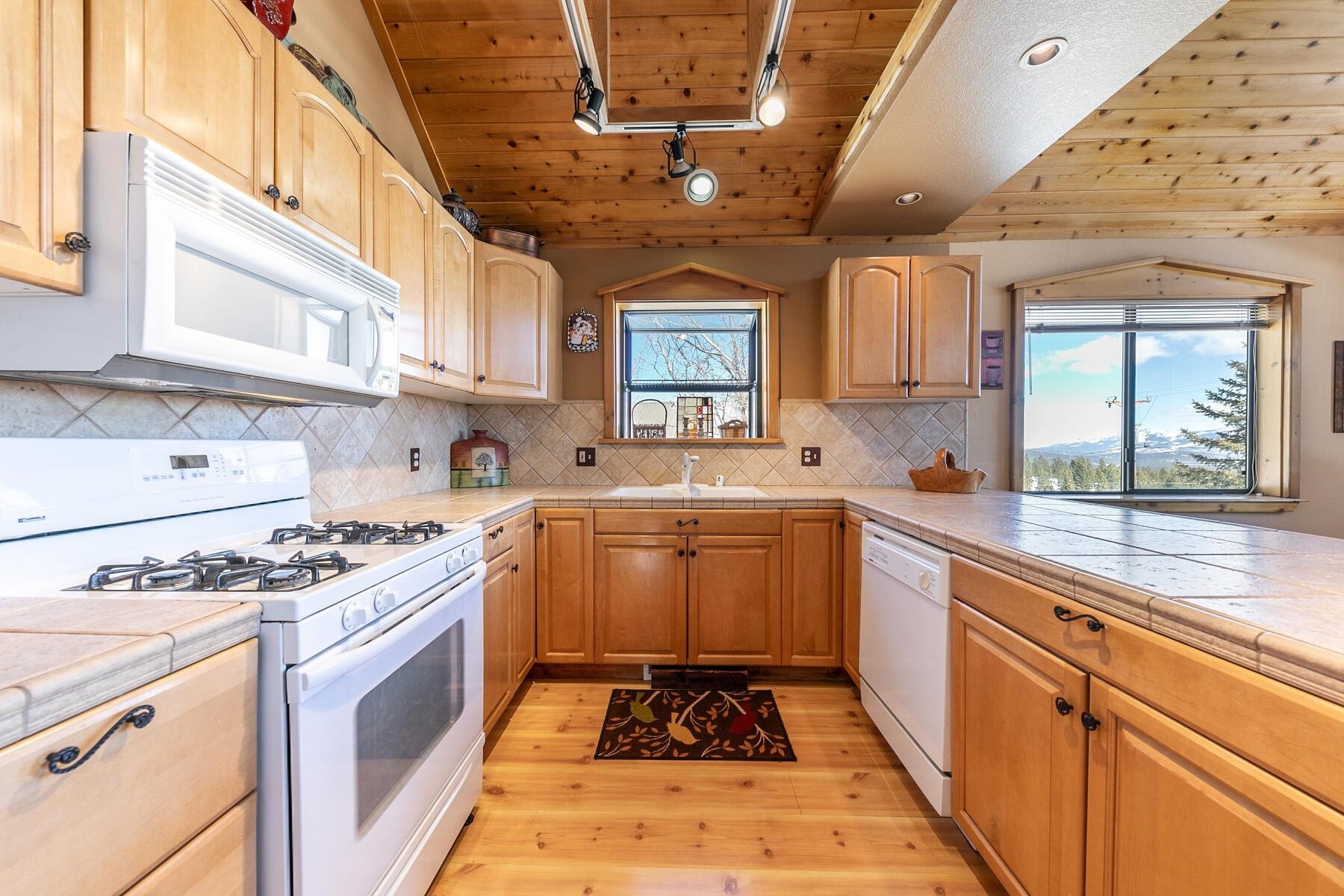 14514 Wolfgang Road Truckee, CA 96161 - Photo 8 of 21 a kitchen with granite countertop a stove sink and cabinets
