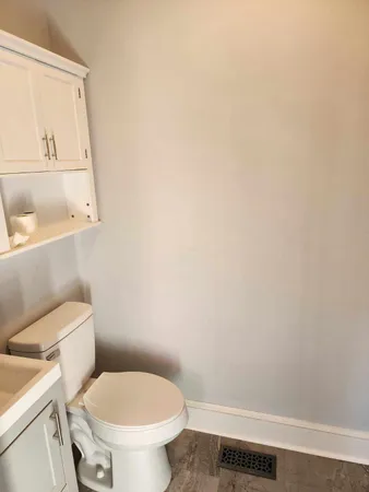 a white toilet sitting next to a white sink and vanity