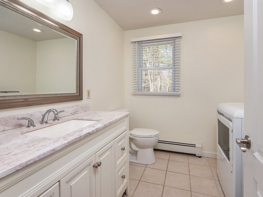 75 J J Davis Road Charlton, MA 01507 - Photo 28 of 33 a bathroom with a granite countertop toilet sink and mirror