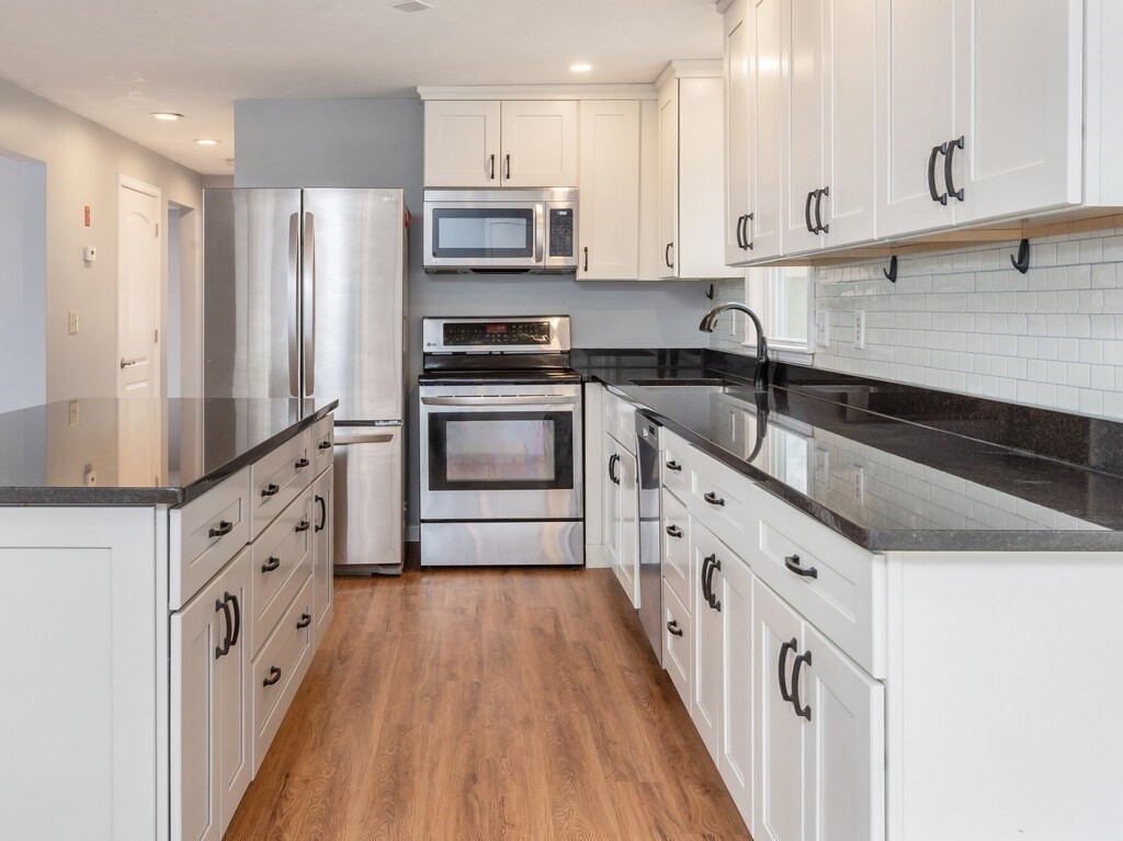 75 J J Davis Road Charlton, MA 01507 - Photo 8 of 33 a kitchen with stainless steel appliances white cabinets a sink a stove a refrigerator and cabinets