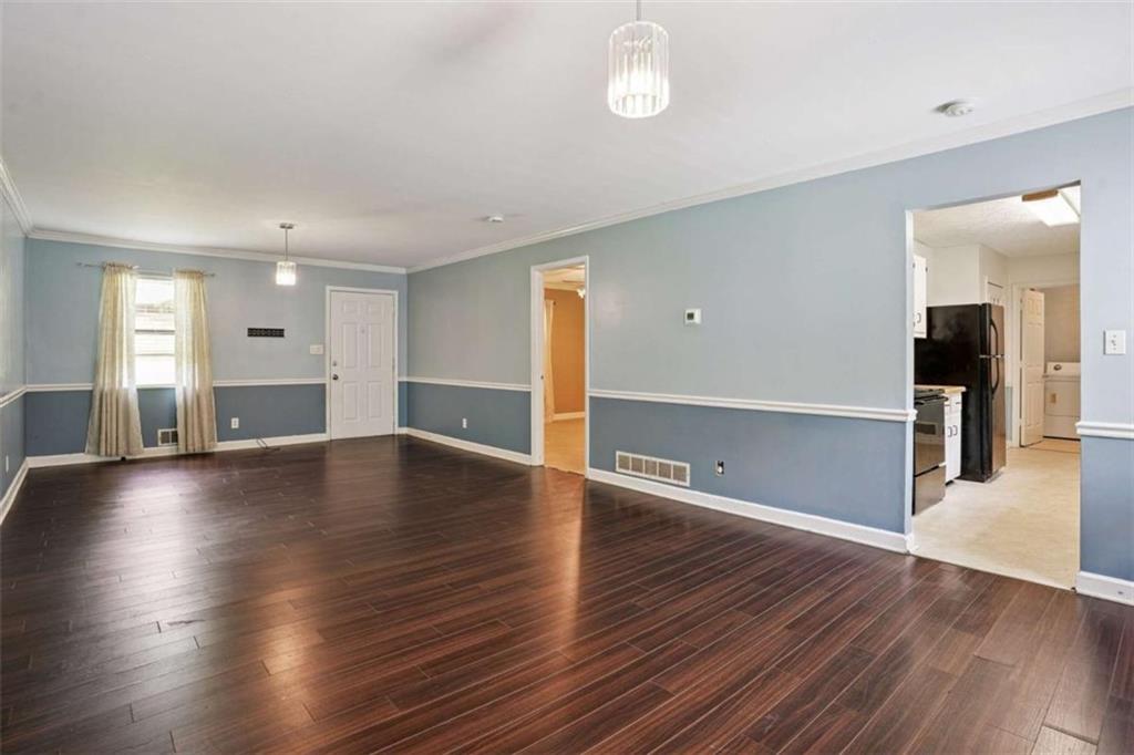 183 Elm Street Covington, GA 30014 - Photo 4 of 23 an empty room with wooden floor and windows