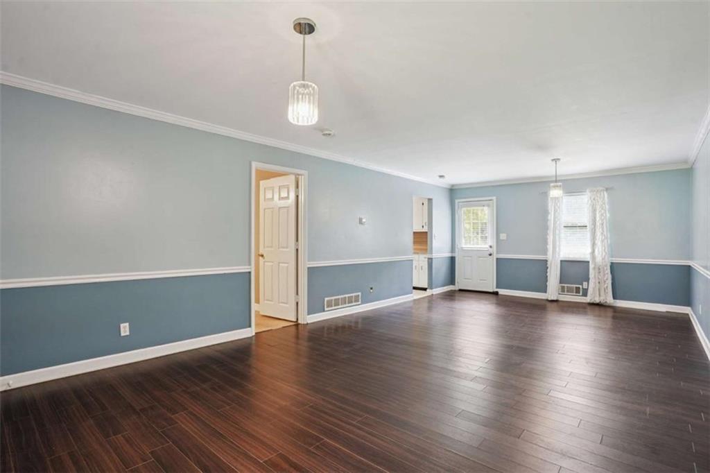 183 Elm Street Covington, GA 30014 - Photo 5 of 23 a view of an empty room with window and wooden floor
