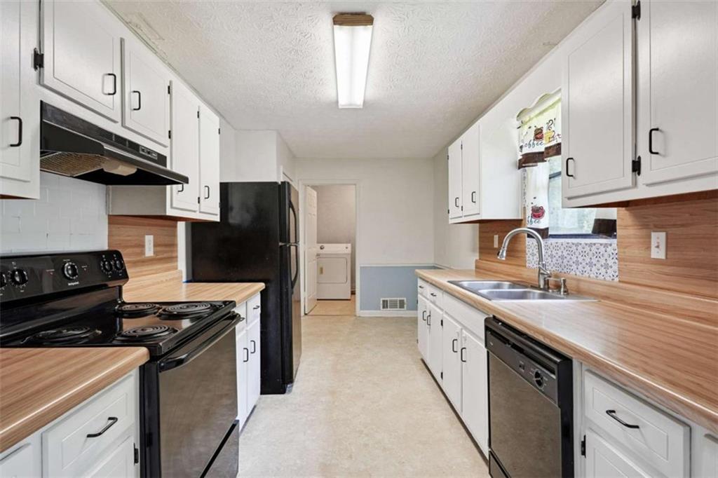 183 Elm Street Covington, GA 30014 - Photo 6 of 23 a kitchen with stainless steel appliances granite countertop a stove and a refrigerator