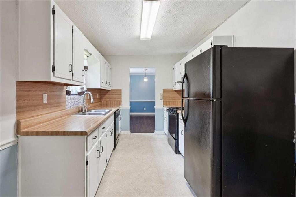 183 Elm Street Covington, GA 30014 - Photo 8 of 23 a kitchen with stainless steel appliances granite countertop a refrigerator and a sink