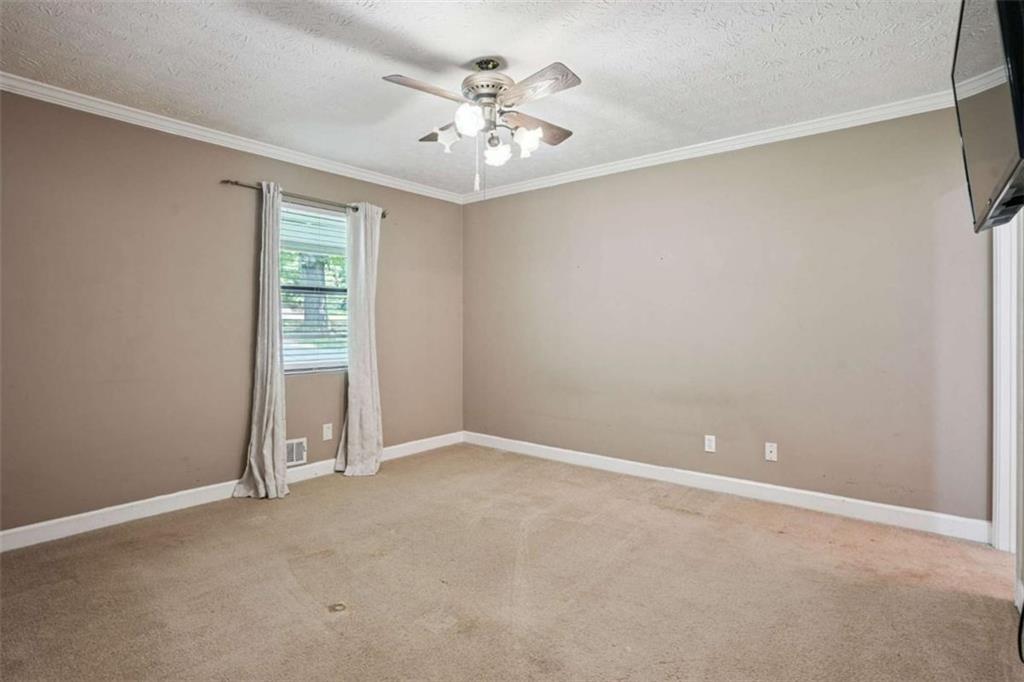 183 Elm Street Covington, GA 30014 - Photo 9 of 23 an empty room with chandelier fan and windows