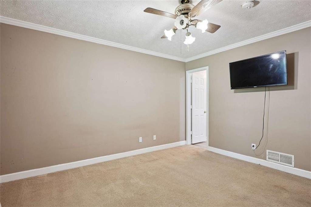 183 Elm Street Covington, GA 30014 - Photo 10 of 23 en empty room with windows and flat screen tv