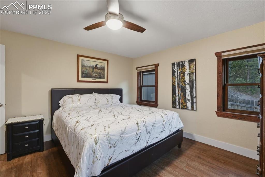 9445 Mohawk Trail Cascade, CO 80809 - Photo 13 of 47 a bedroom with a large bed and a chandelier