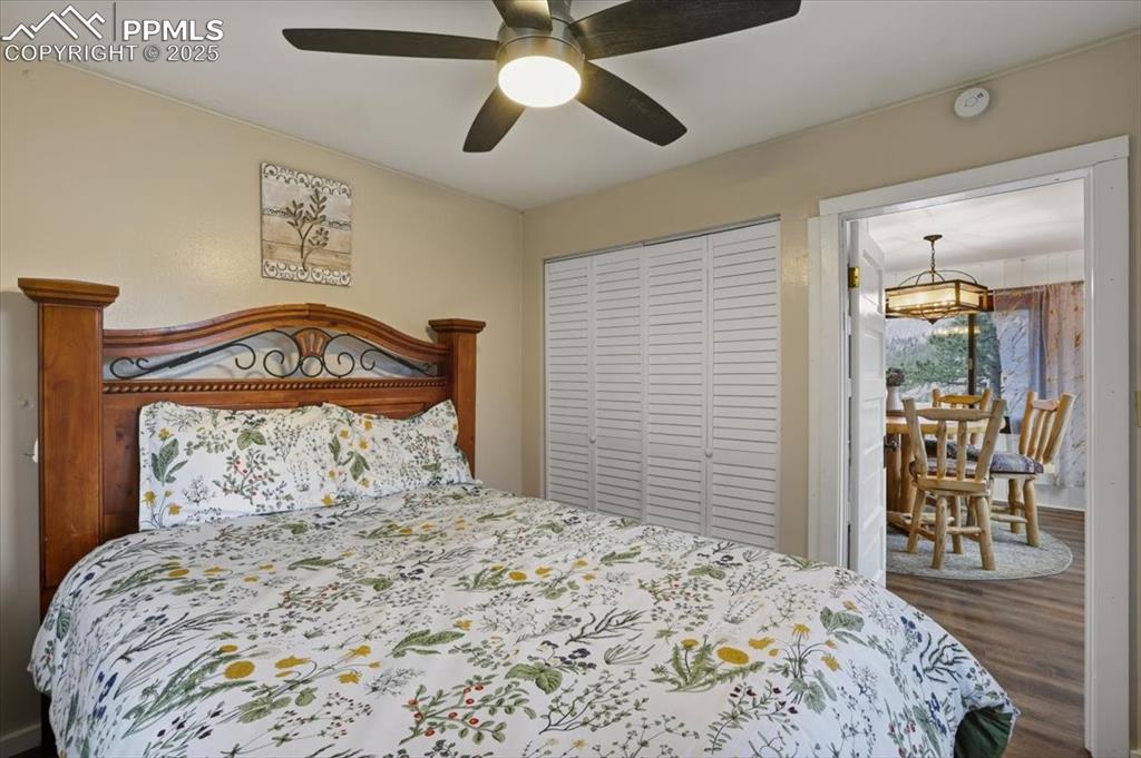 9445 Mohawk Trail Cascade, CO 80809 - Photo 25 of 47 a bedroom with a bed and a chandelier