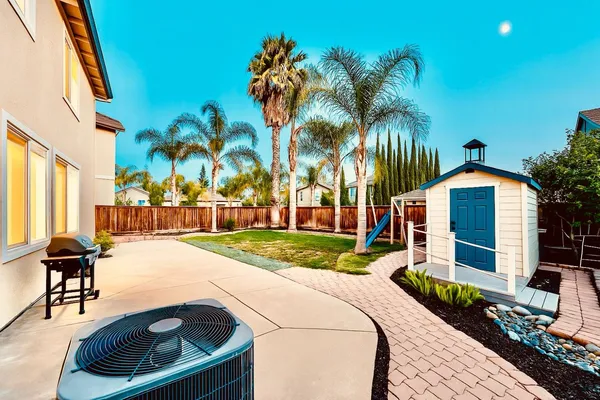 a front view of a house with a yard and potted plants