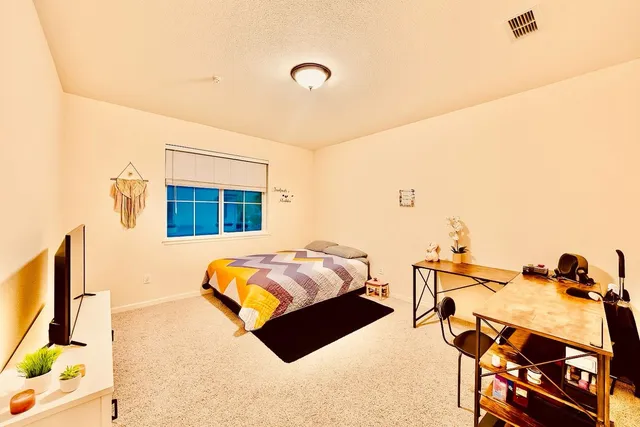 a view of an empty room with wooden floor and a chandelier