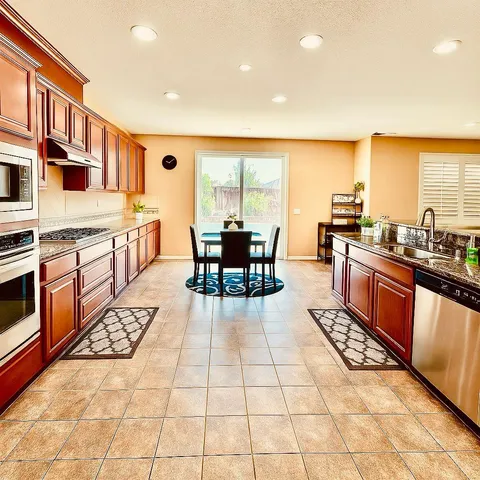 a kitchen with stainless steel appliances kitchen island granite countertop a sink and cabinets