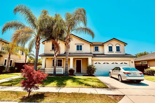 a view of a house with a swimming pool and a yard