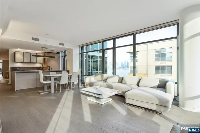 a living room with furniture and floor to ceiling windows
