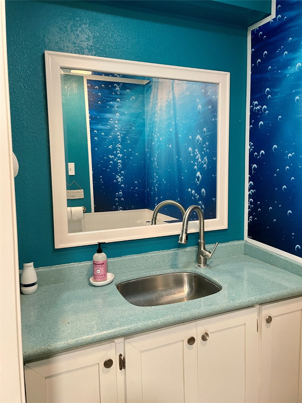 101 Salt Grass Avenue Surfside Beach, TX 77541 - Photo 30 of 48 a kitchen with a sink and a large mirror