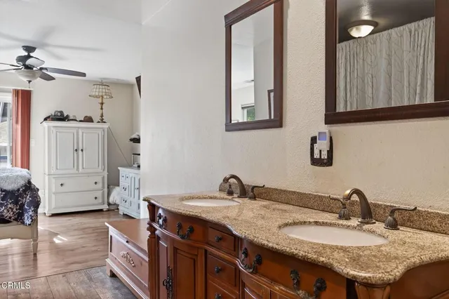 a en suite bathroom with a granite countertop sink and a mirror