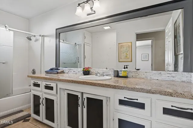 a bathroom with a granite countertop sink two mirror and a