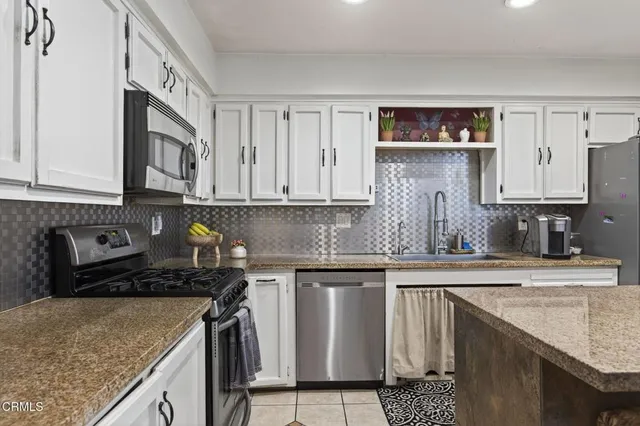 a kitchen with stainless steel appliances granite countertop a sink stove and cabinets