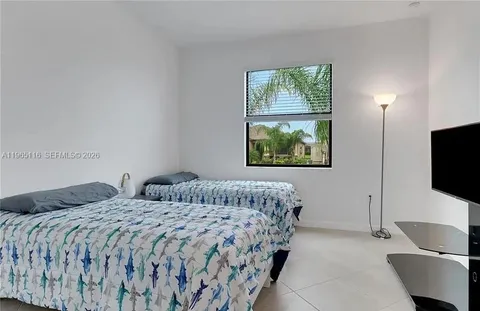 a bedroom with two beds and a flat screen tv