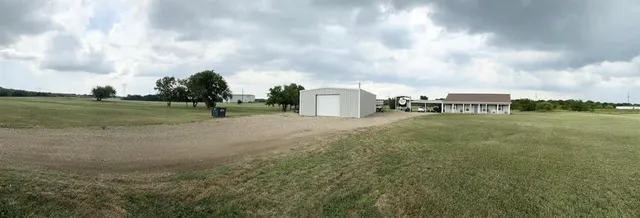 a view of a big yard with beach and barbeque oven