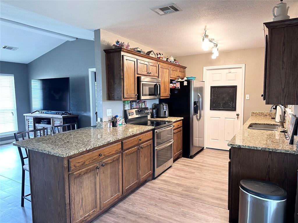 12638 Highway 82 Savoy, TX 75479 - Photo 18 of 21 a kitchen with stainless steel appliances granite countertop a sink stove and refrigerator