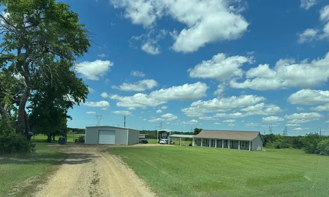 a view of residential houses with yard and lake view in back