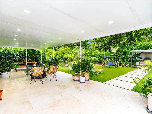 a view of a patio with a table and chairs next to a yard