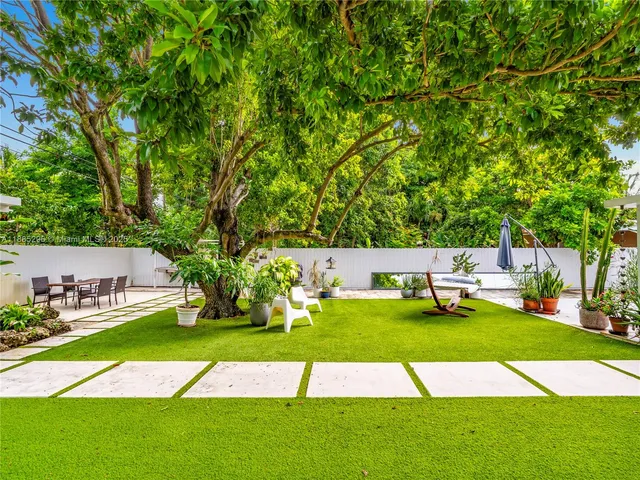 a view of an chairs and yard with swimming pool