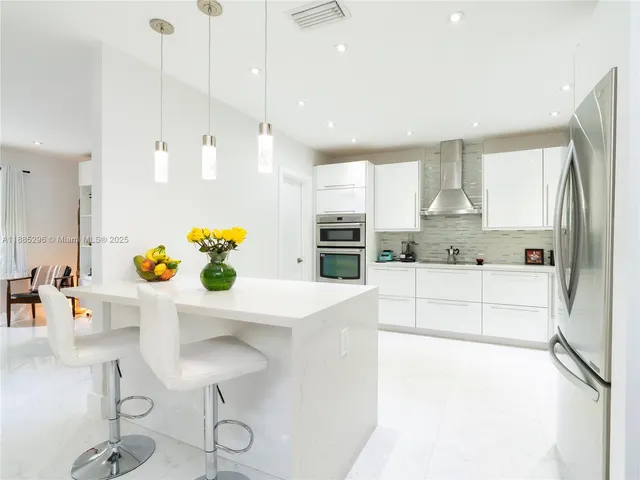a kitchen with stainless steel appliances granite countertop a sink and a refrigerator