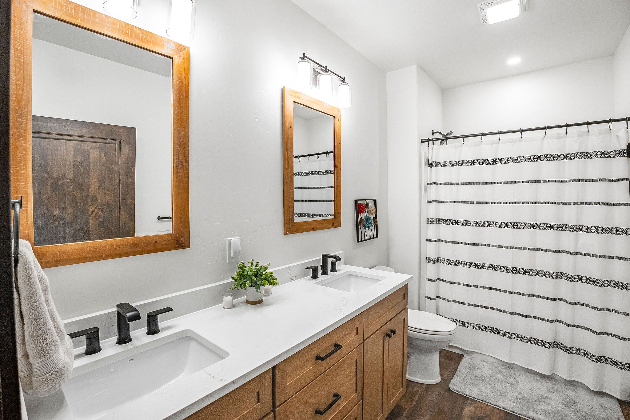 77 Rumsey Road Philipsburg, MT 59858 - Photo 43 of 76 Bathroom featuring toilet, double vanity, wood finished floors, curtained shower, and recessed lighting